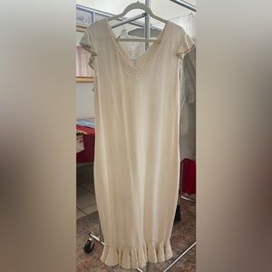 Custom knit dress in ivory with gold neckline ruffled cap sleeves and hem.